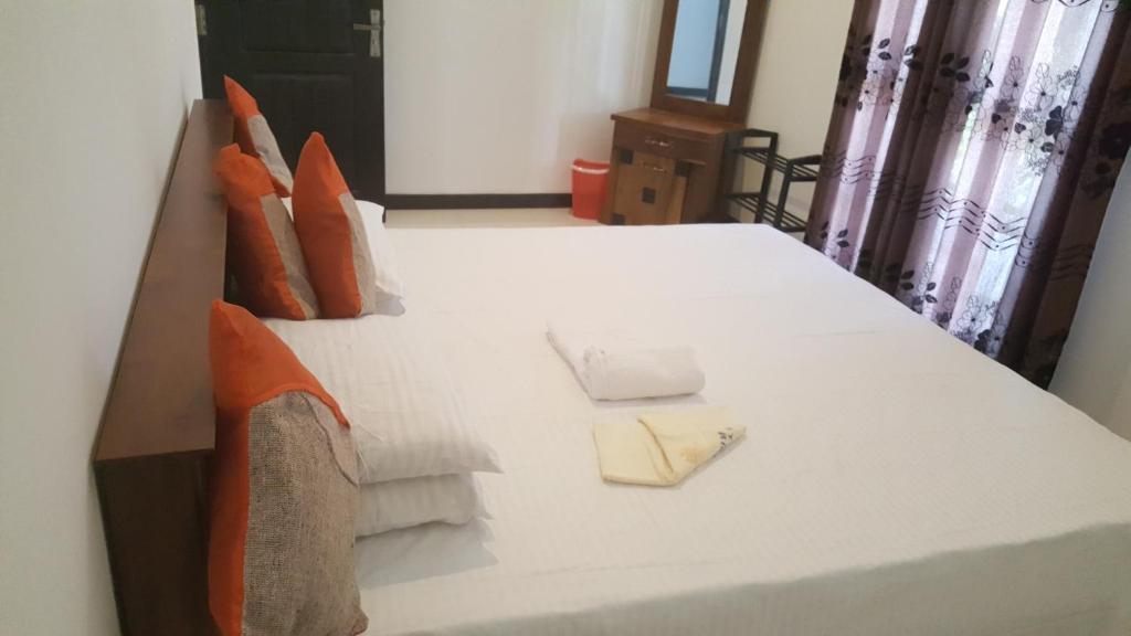 duże białe łóżko z ręcznikami i poduszkami w obiekcie COCO Rooms w mieście Galle