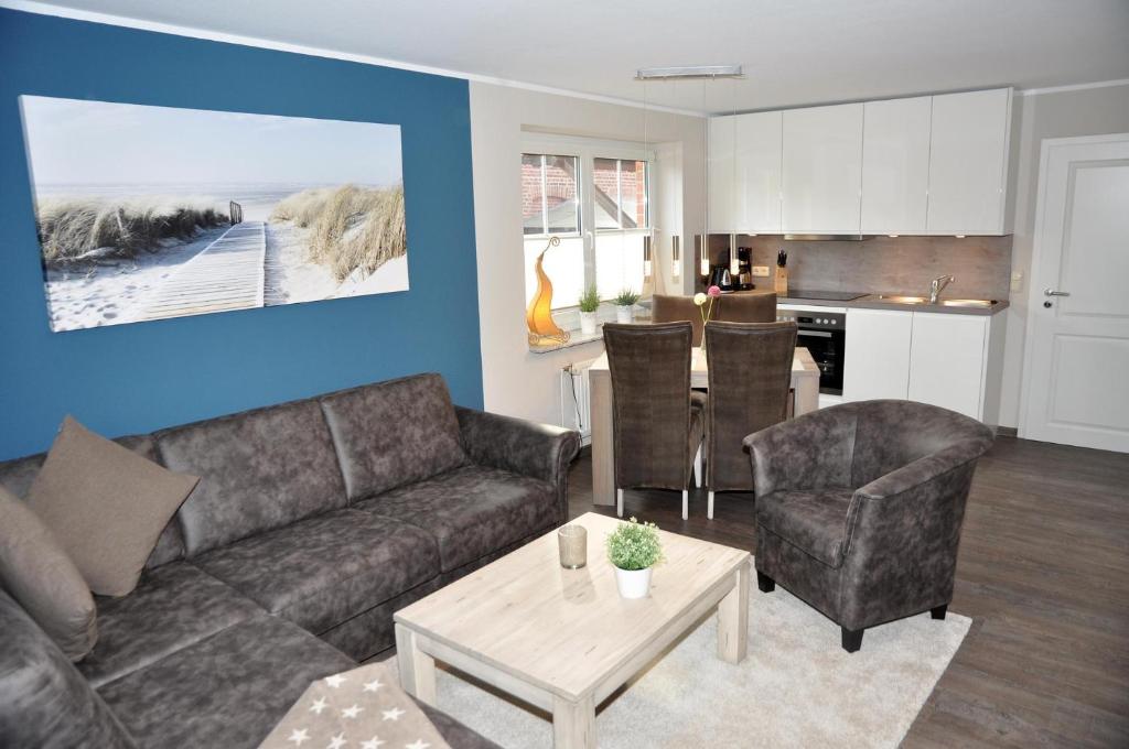 a living room with a couch and a table and a kitchen at Bellevue 02 in Laboe