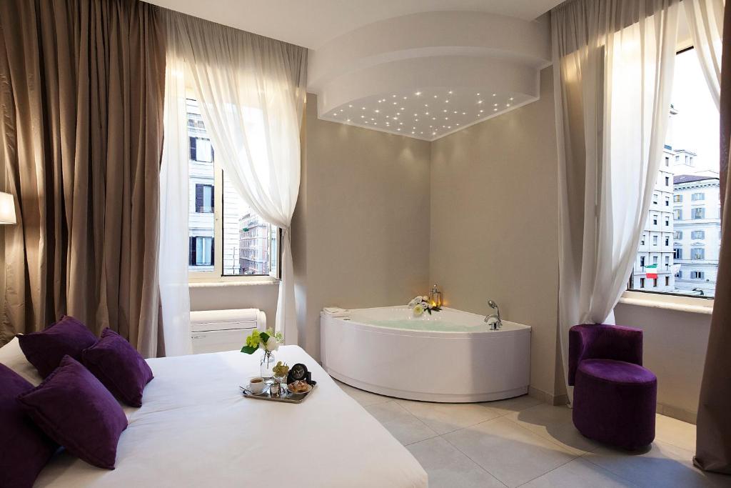 - une chambre avec une baignoire et un lit aux accents violets dans l'établissement Roman Holidays Boutique, à Rome