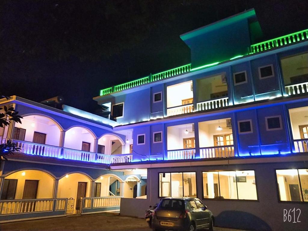 Dom's Inn في كالانغيُت: مبنى ازرق تقف امامه سيارة