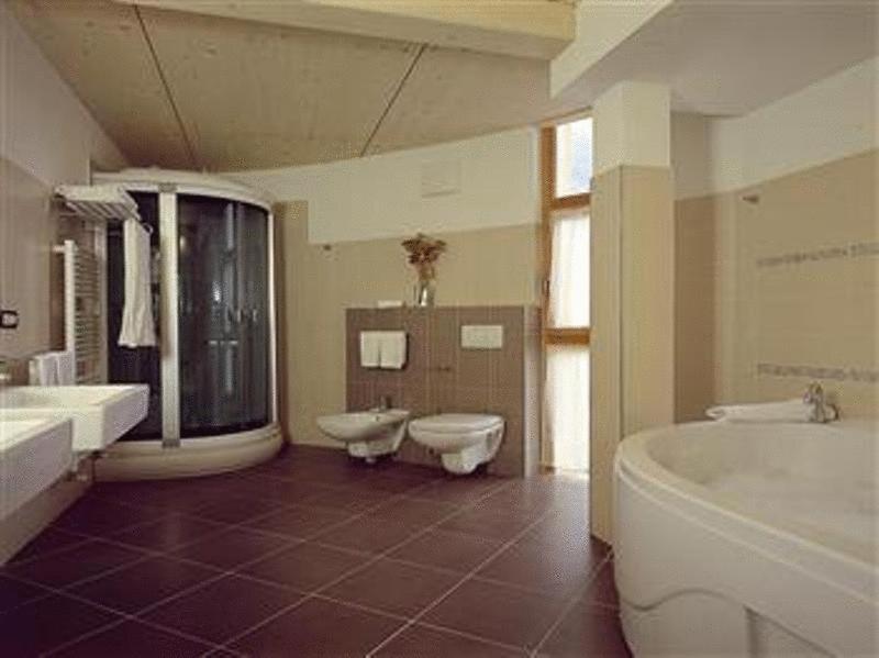 łazienka z 2 umywalkami, wanną i toaletą w obiekcie Bio Hotel Benny w mieście Commezzadura