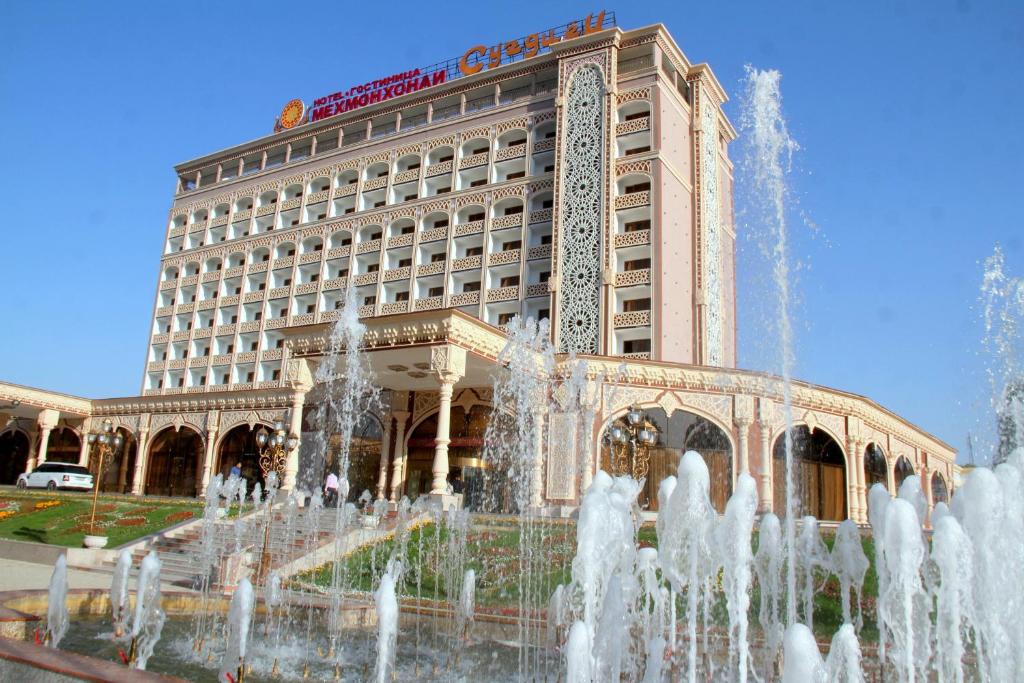 a large building with a fountain in front of it at Sugdiyon Hotel in Khujand