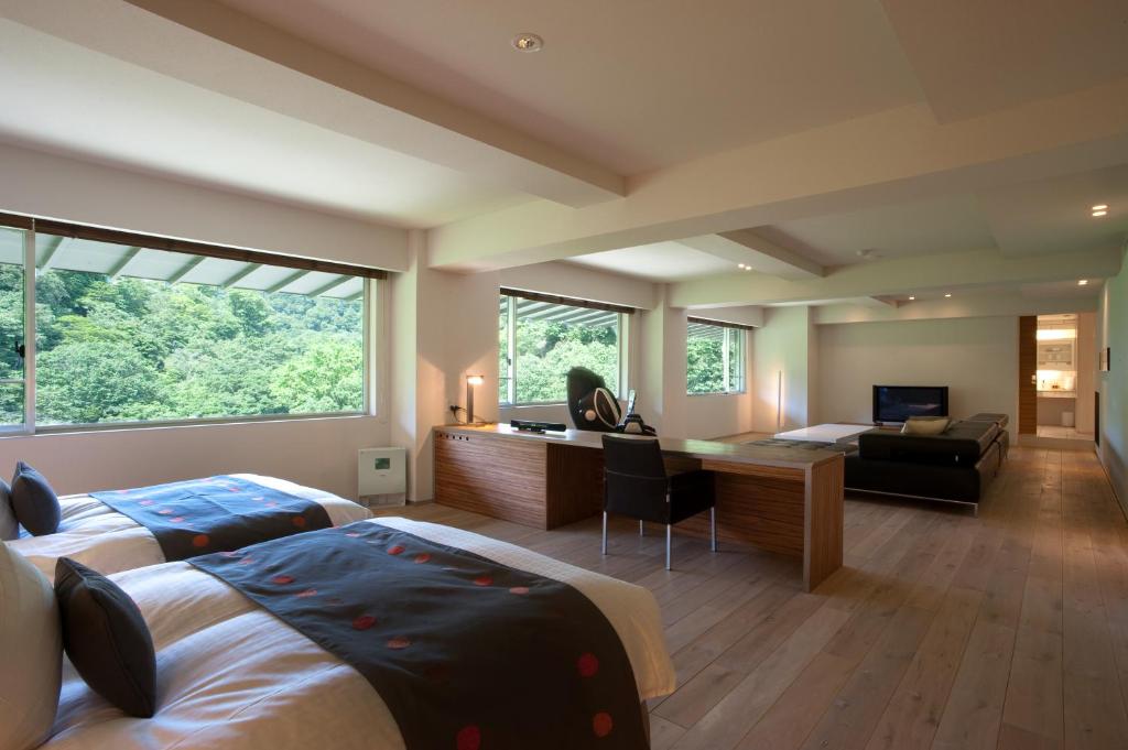 1 dormitorio con 2 camas, escritorio y sofá en Bourou NOGUCHI Noboribetsu (Adult Only), en Noboribetsu