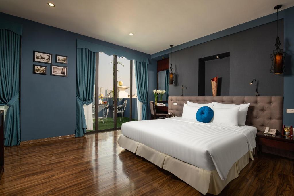 Schlafzimmer mit einem großen weißen Bett und blauen Wänden in der Unterkunft Serene Boutique Hotel & Spa in Hanoi