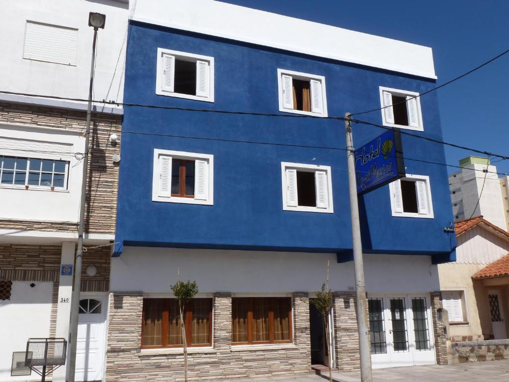 un edificio azul y blanco con ventanas blancas en Hotel Azul Marino en Santa Teresita