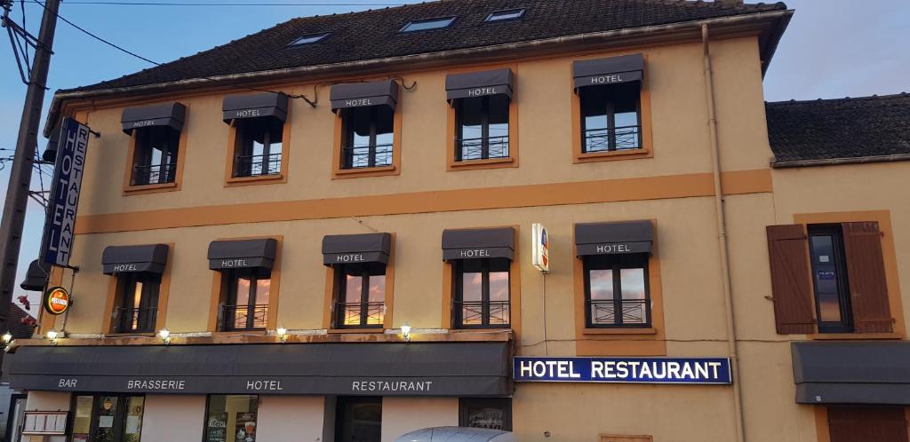 a large building with a hotel restaurant sign on it at LE PETIT FOSSARD Montereau - Fontainebleau in Le Petit-Fossard