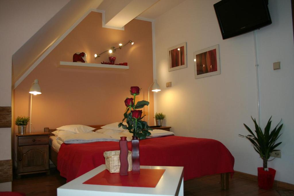 1 dormitorio con 1 cama con manta roja en Apartamenty Centrum Zakopane, en Zakopane