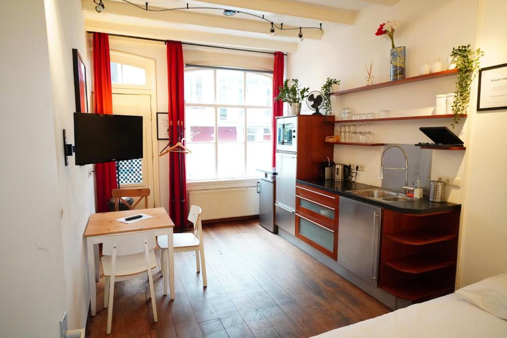 a small kitchen with a small table and a desk at Kerkstraat Bed and Breakfast Apartment with private Garden in Amsterdam