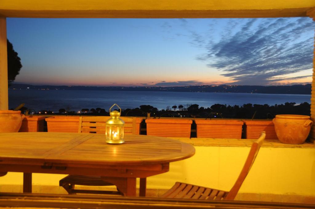 a table on a balcony with a view of the ocean at Appartamento Sabatinus in Trevignano Romano