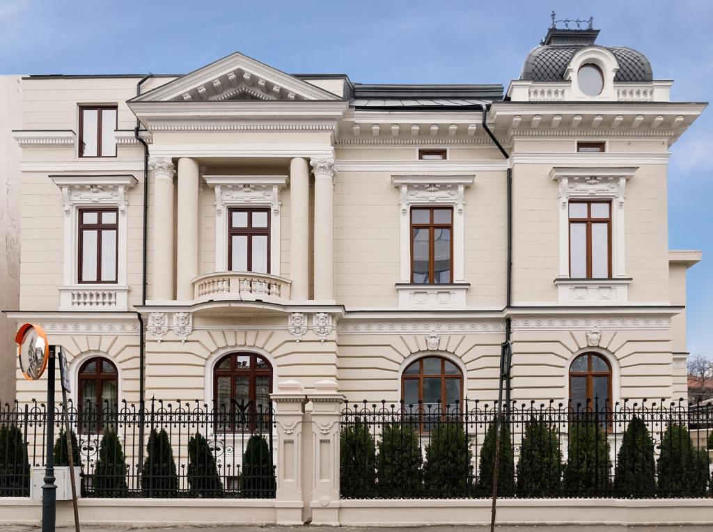 una casa blanca con una valla delante en Lahovary Palace Hotel en Bucarest