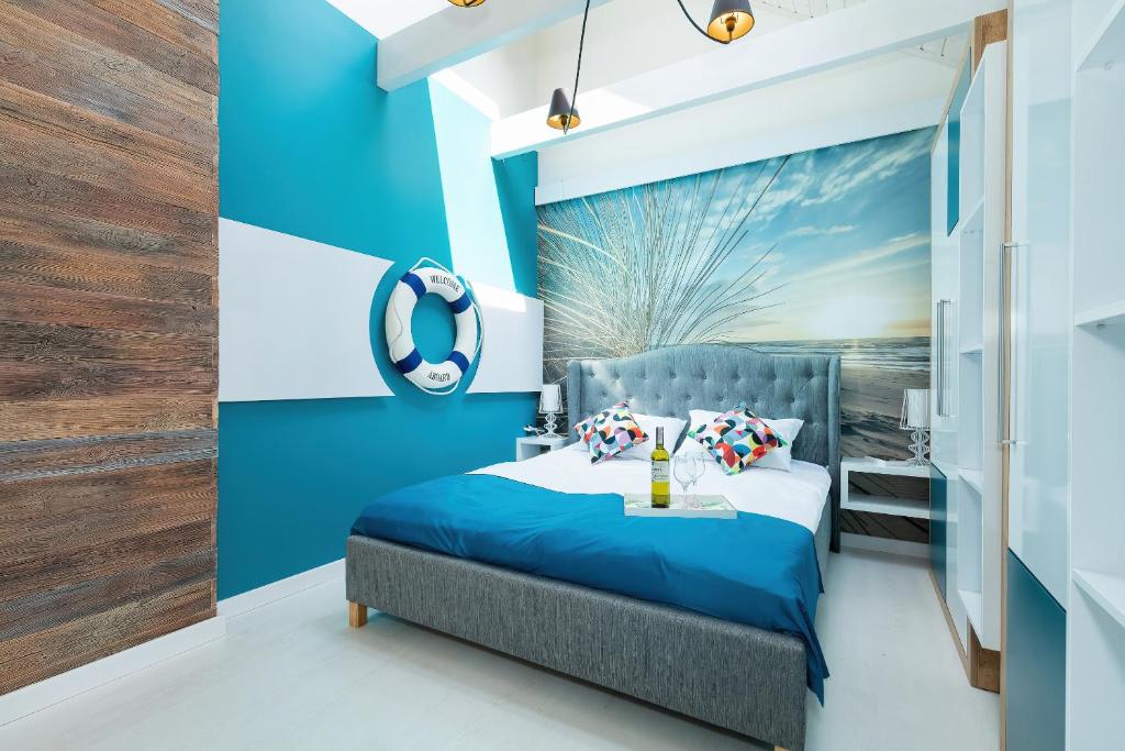 a blue bedroom with a bed and a blue wall at Osada Family Park in Ustronie Morskie