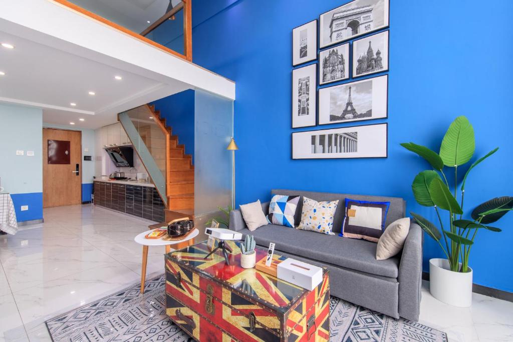 a living room with blue walls and a couch at Tianjin Hedong·Wanda Plaza· in Tianjin