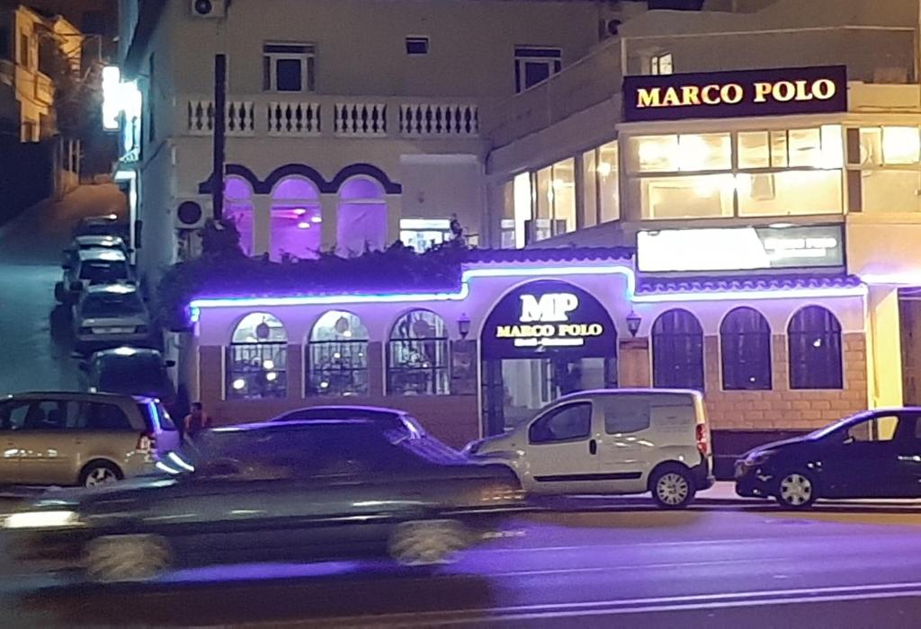 une voiture garée devant un immeuble de polo marco dans l'établissement Marco Polo, à Tanger