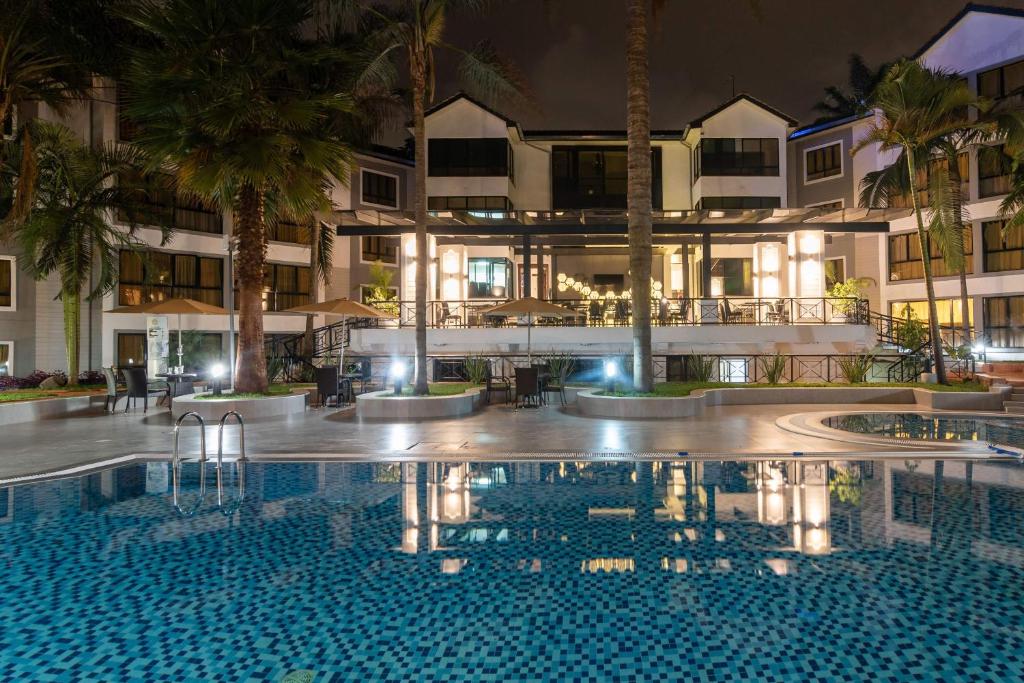 ein Hotel mit einem Pool vor einem Gebäude in der Unterkunft CySuites Apartment Hotel in Nairobi