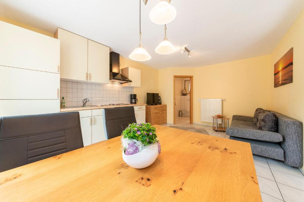 een keuken en een woonkamer met een houten tafel bij Ferienwohnung Bruttel in Gaienhofen