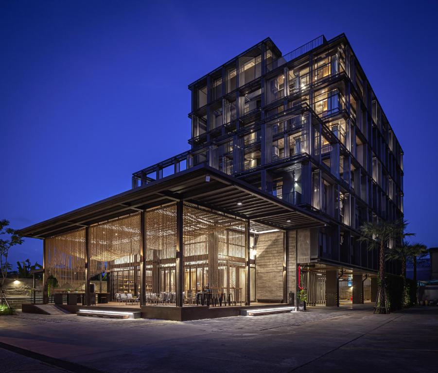 a large building with glass windows at night at Navakitel Design Hotel in Nakhon Si Thammarat