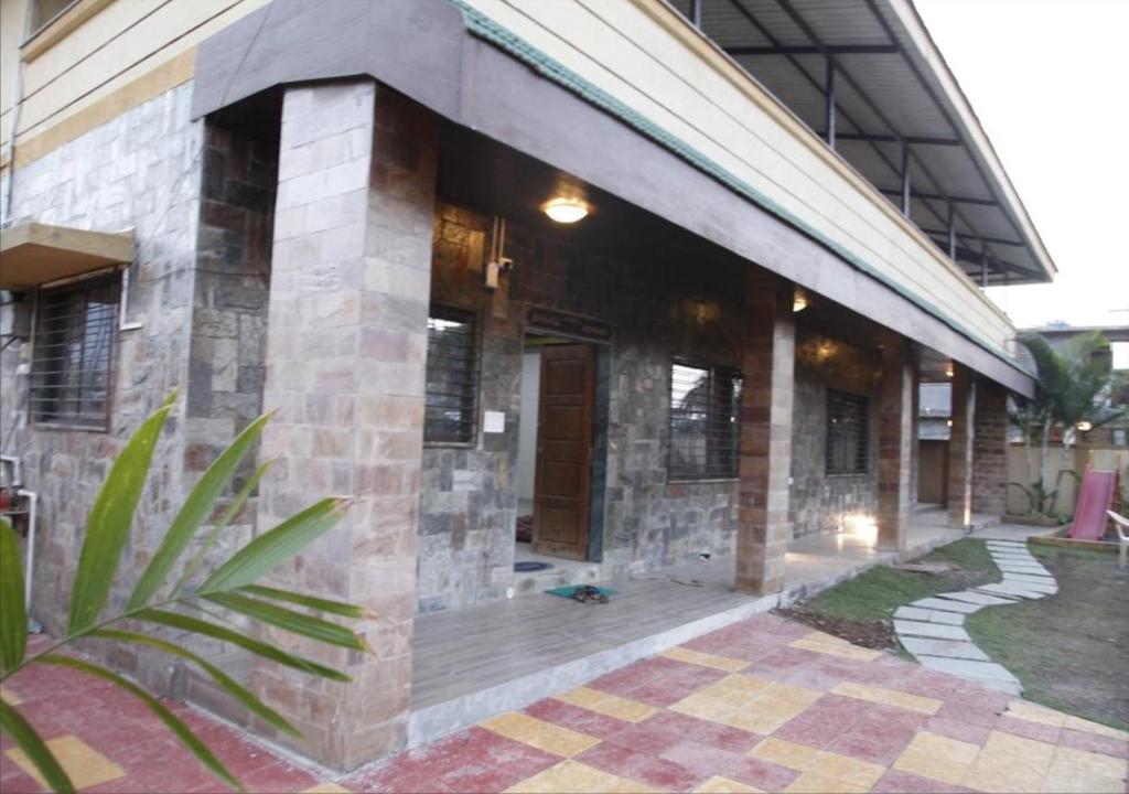 a brick building with a walkway in front of it at Ivy Orchids Villa - Lonavala in Lonavala