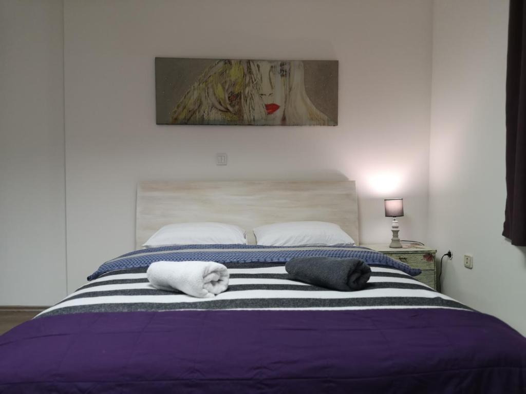a bed with two pillows with a dog laying on it at Rooms Madison in Zagreb