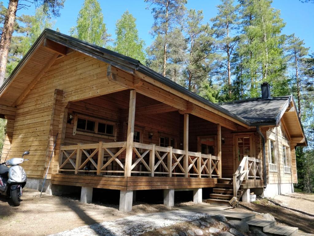 a log cabin with a motorcycle parked in front of it at Rantahuvila Virranniemi in Vehkataipale