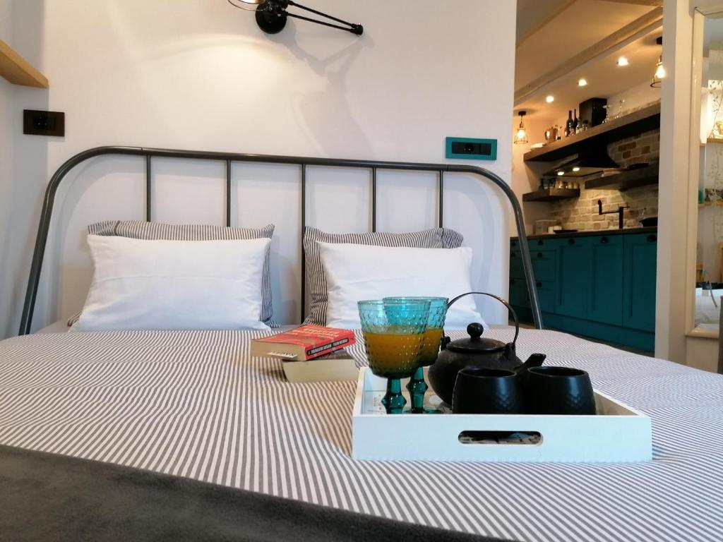 a tray with a drink and books on a bed at Apartman Kika in Poreč