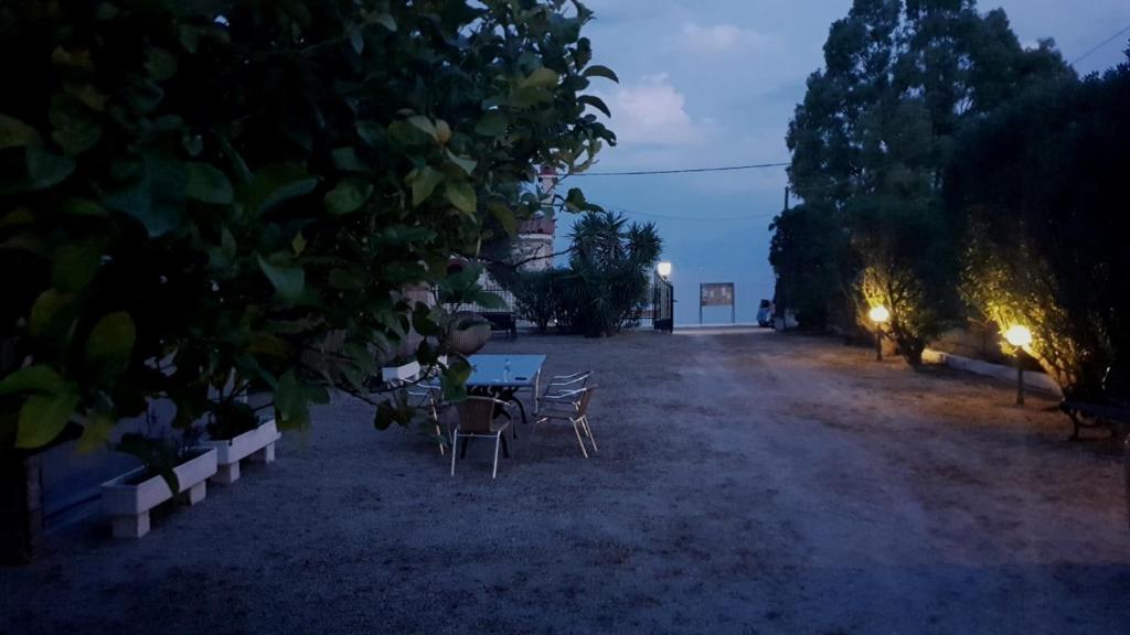 einen Tisch und Stühle in einem Garten in der Nacht in der Unterkunft Oasis Studios AG PANTES in Áyioi Pándes