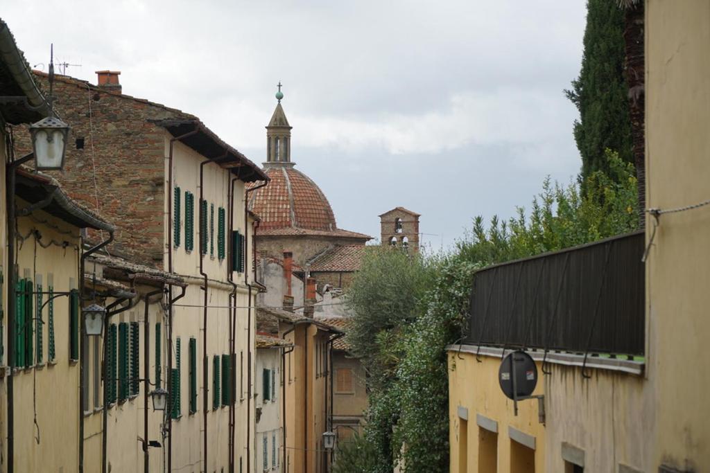 a city street with buildings and a church in the background at Appartamento Mariapaola in Arezzo