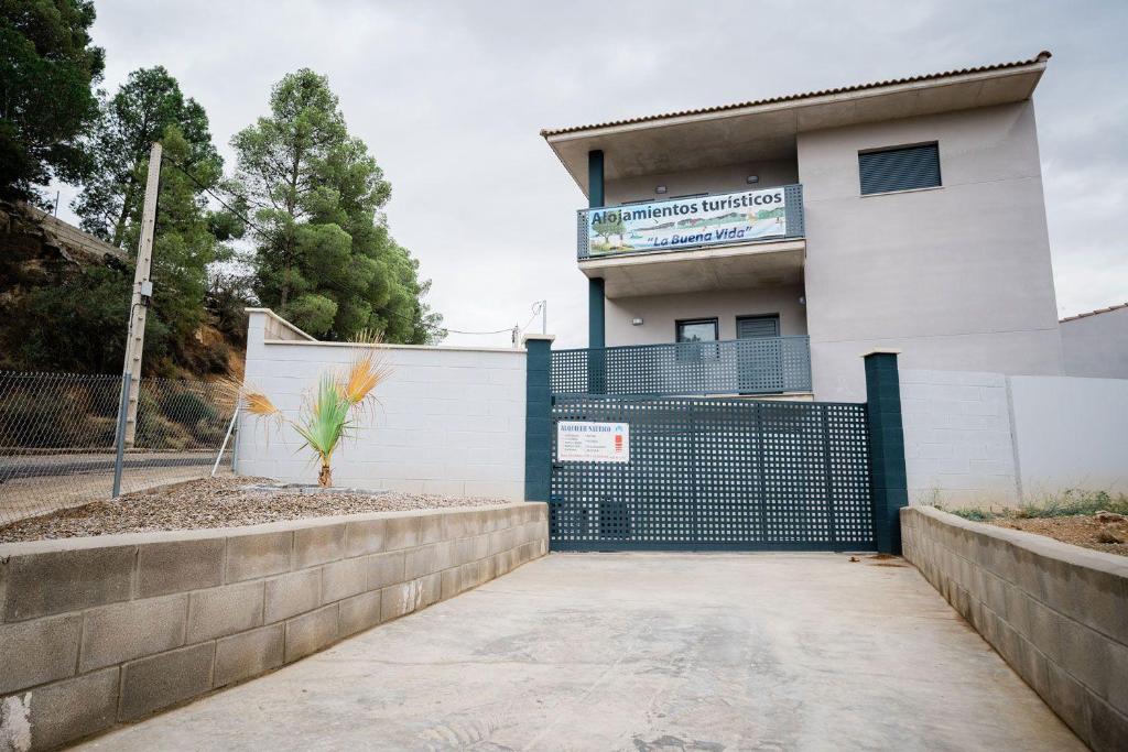 un edificio con una puerta y una valla en Pensión La Buena Vida, en Caspe