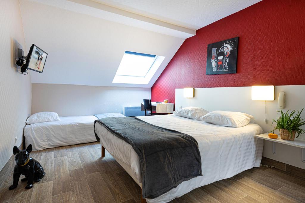 a bedroom with two beds and a dog sitting on the floor at Hotel-Restaurant Espace Squash 3000 in Mulhouse