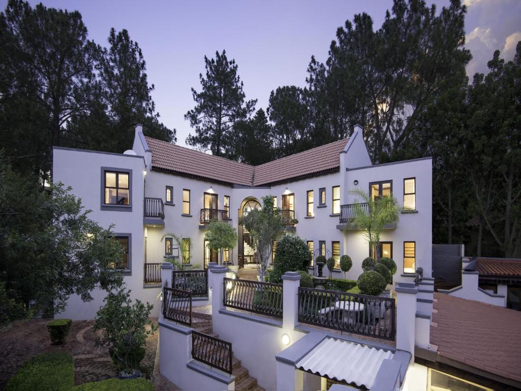 an exterior view of a large white house at Bohemian Guesthouse - Pretoria in Pretoria