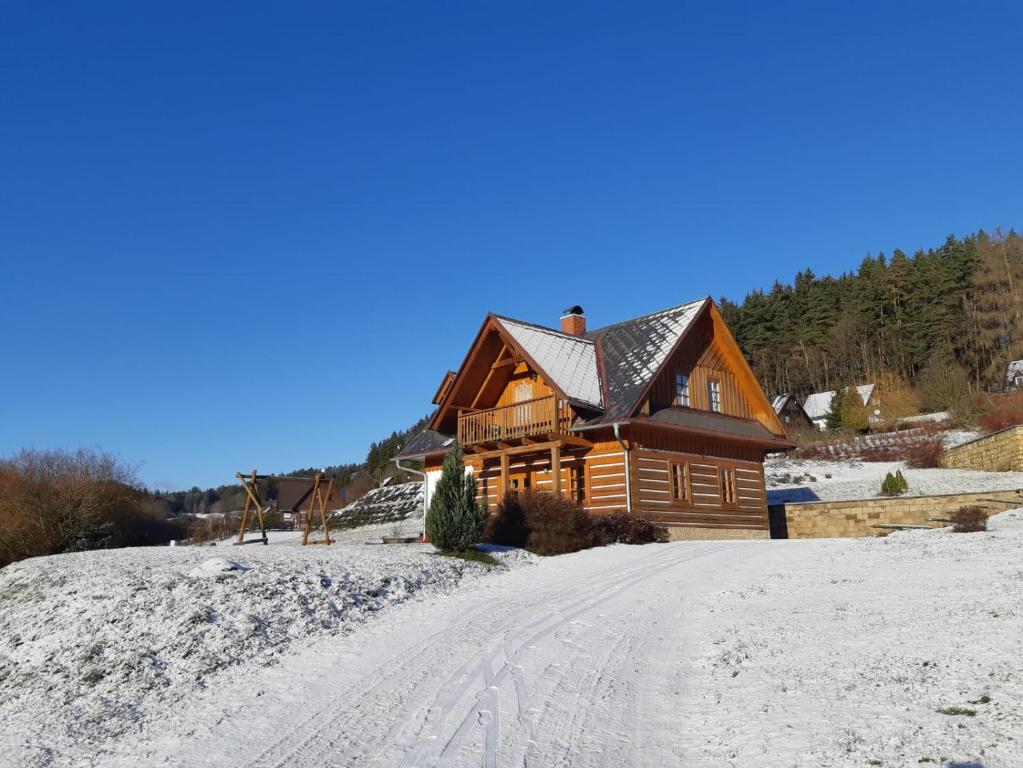 a log cabin in the snow on a road at Holiday Villa Stupna in Vidochov