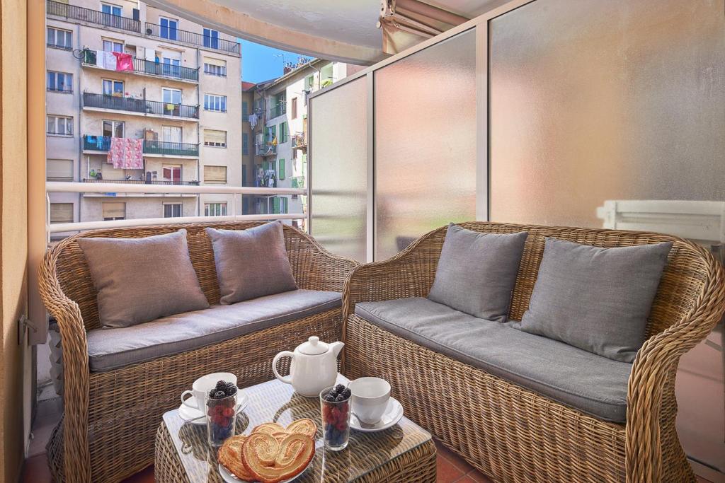 2 chaises en osier et une table sur un balcon dans l'établissement 