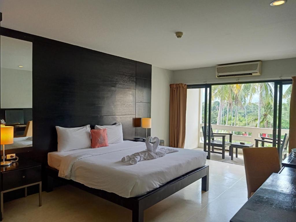 a bedroom with a large bed and a balcony at Amarin Samui Hotel - SHA Plus Certified in Mae Nam
