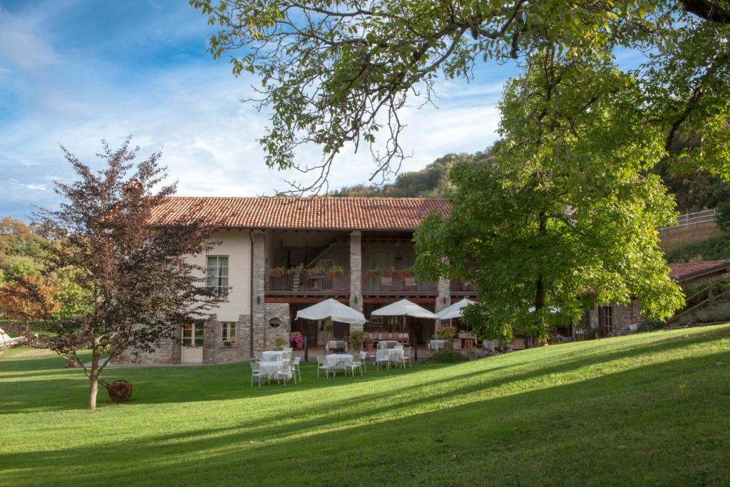 a building with tables and chairs on a lawn at Agriturismo La Tesa in Iseo