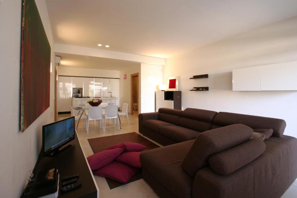 a living room with a brown couch and a television at VILLA DELFINI 2-12 Pax in San Vito lo Capo
