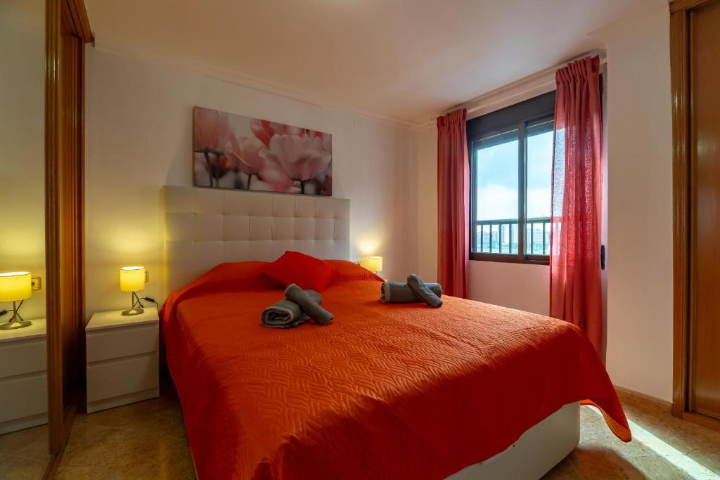 ein Schlafzimmer mit einem roten Bett und einem Fenster in der Unterkunft Moderno apartamento en Valencia para 6 personas in Valencia