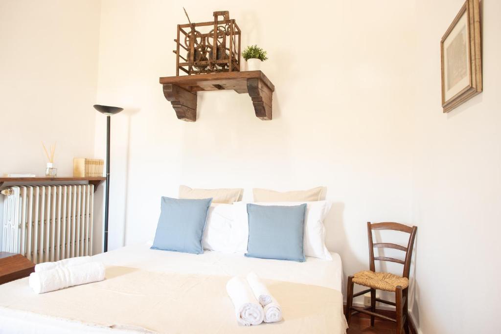 - une chambre avec un lit doté d'oreillers bleus et d'une chaise dans l'établissement Costanza - Appartamento in Torre, à Cerreto Guidi