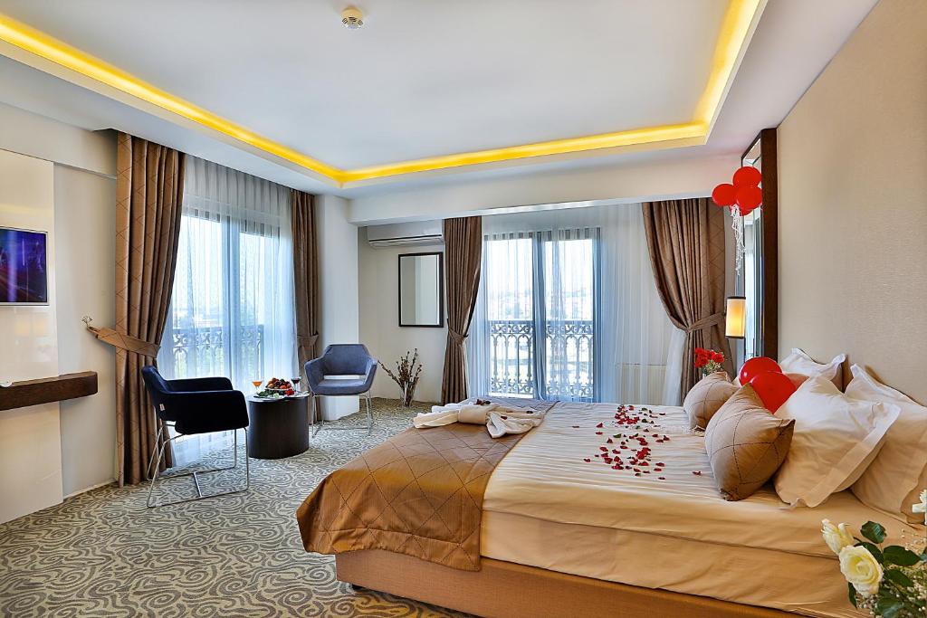 イスタンブールにあるグランド サグランジャー ホテルの赤い花が飾られた大きなベッドが備わるホテルルームです。