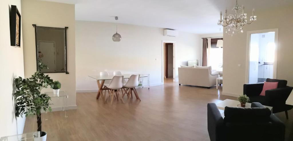 マラガにあるEspectacular Apartamento Malaga Playa Y Piscinaのリビングルーム(テーブル、椅子付)