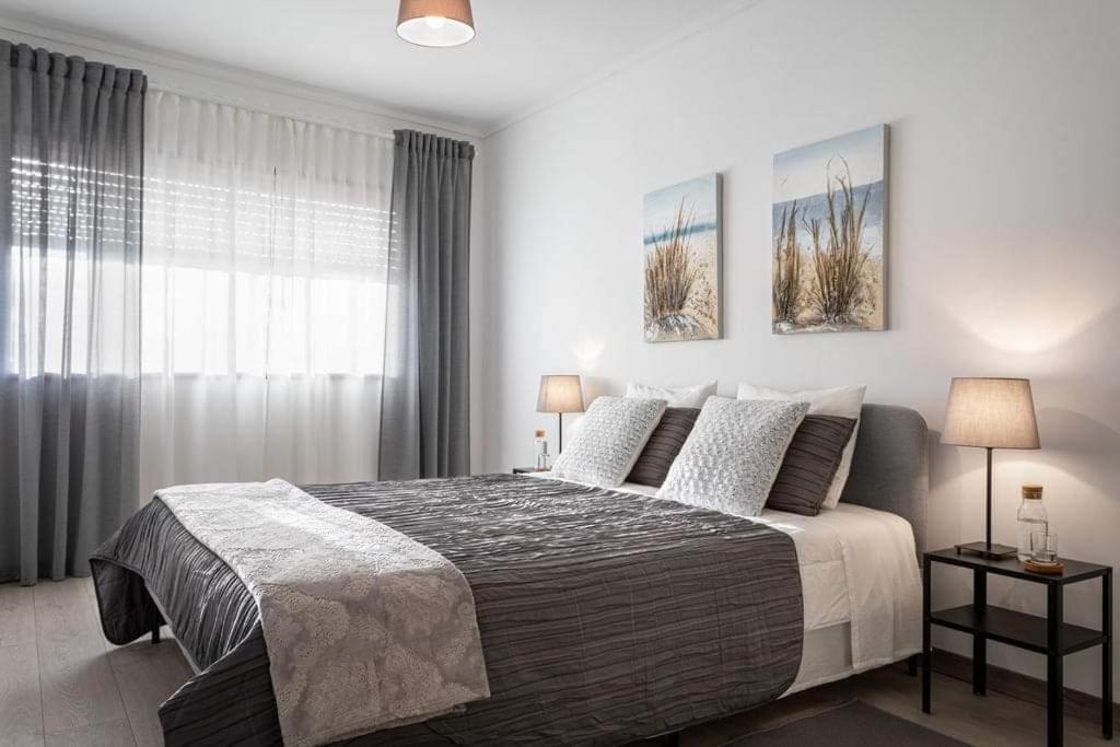 a bedroom with a large bed and a window at Home Sweet Home in Ílhavo