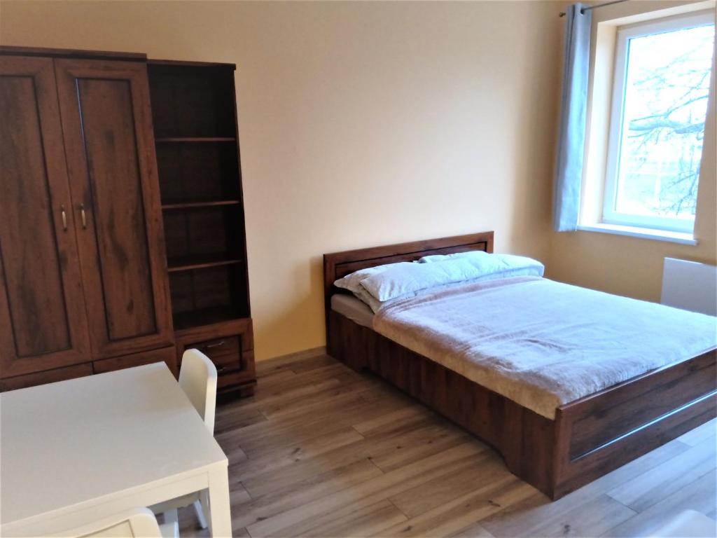 Schlafzimmer mit einem Bett, einem Tisch und einem Fenster in der Unterkunft Studio Daola in Danzig