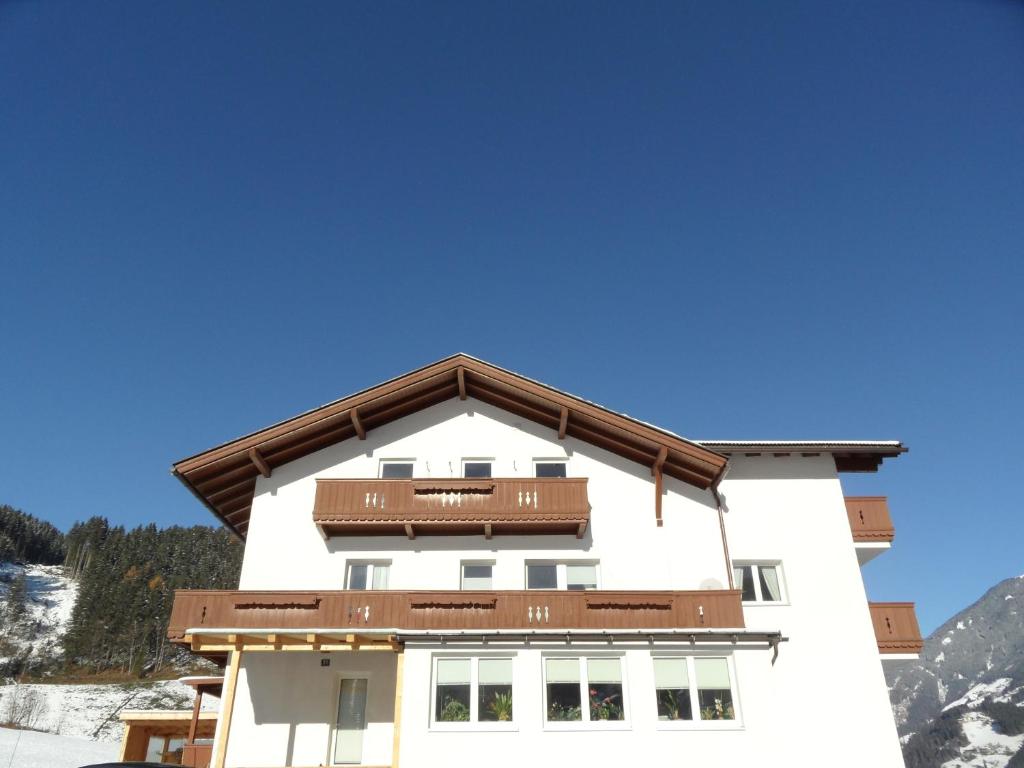ein weißes Gebäude mit braunem Dach in der Unterkunft Appartement Reiter in Aschau