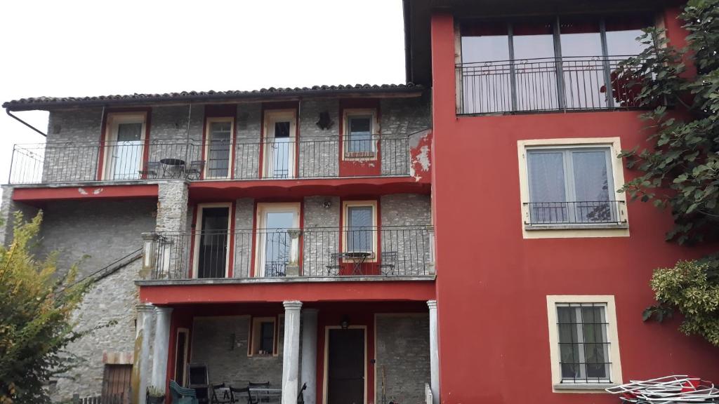 un edificio rosso con finestre e balconi di Agriturismo Cascina Binelli a Dogliani