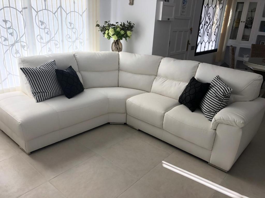 a white couch with pillows sitting in a living room at Casa MoJo in Puerto del Carmen