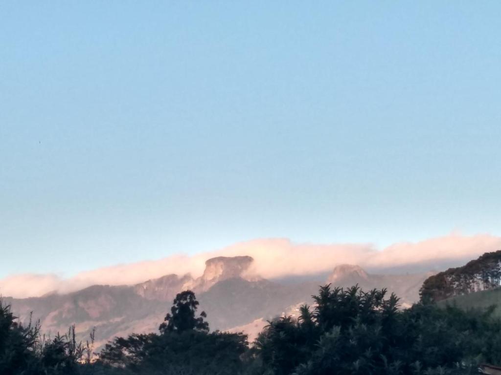 uma vista para uma montanha com nuvens no céu em Quarto Aconchegante em São Bento do Sapucaí