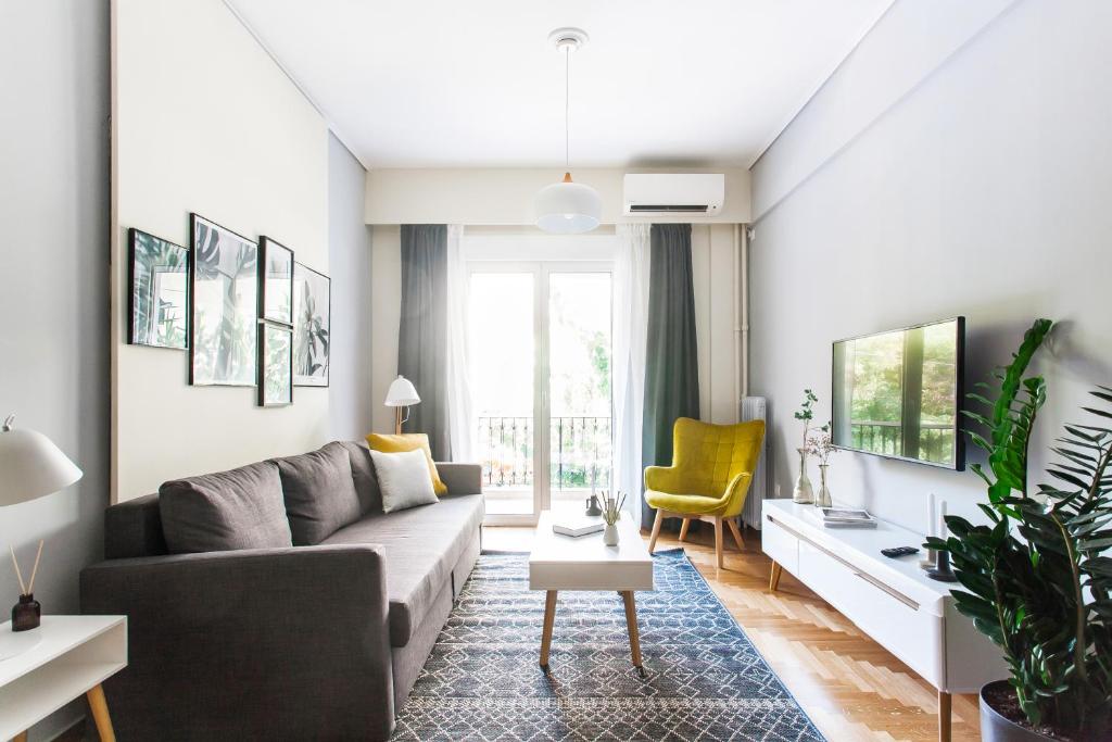a living room with a gray couch and a yellow chair at Charming & Comfy 2BD Apartment in Acropolis Area by UPSTREET in Athens