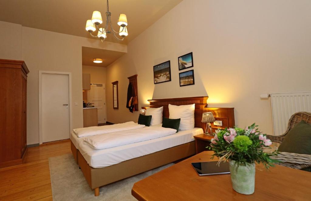ein Hotelzimmer mit einem Bett und einem Tisch in der Unterkunft Aparthotel Markt Fuffzehn in Stralsund