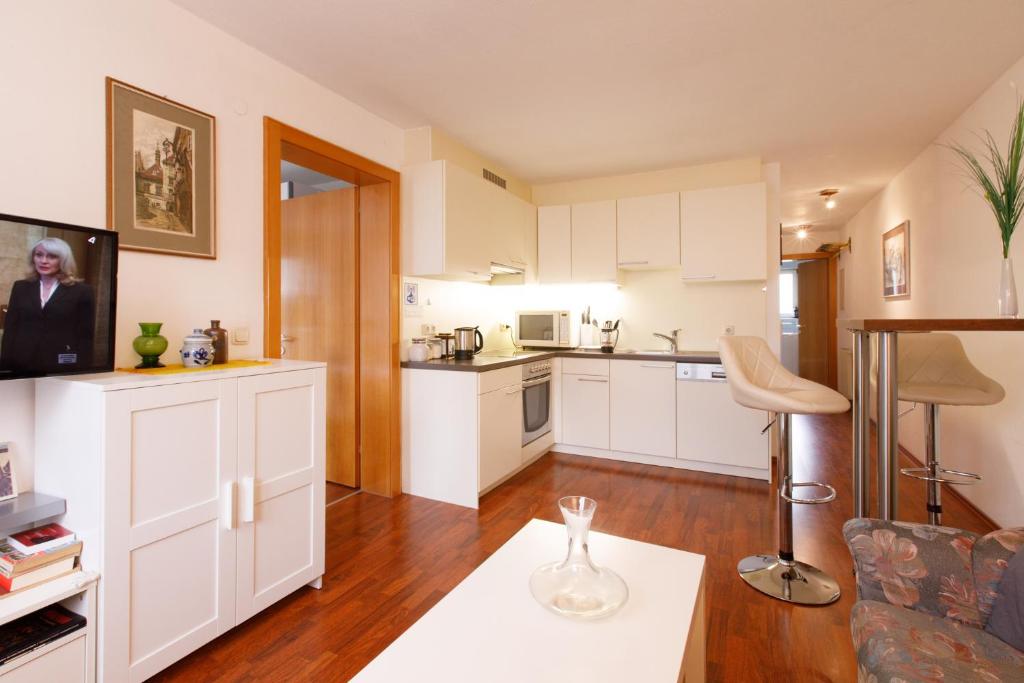 a kitchen with white cabinets and a living room at Dimai House No 15 Dornbirn Zentrum in Dornbirn