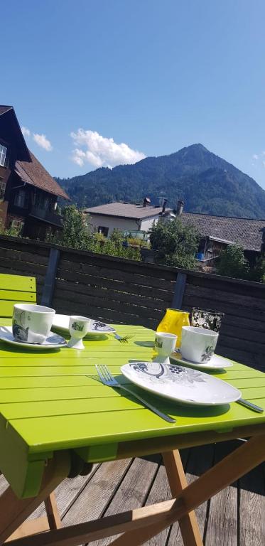 a green table with plates and cups on a deck at Dimai House No 15 Dornbirn Zentrum in Dornbirn