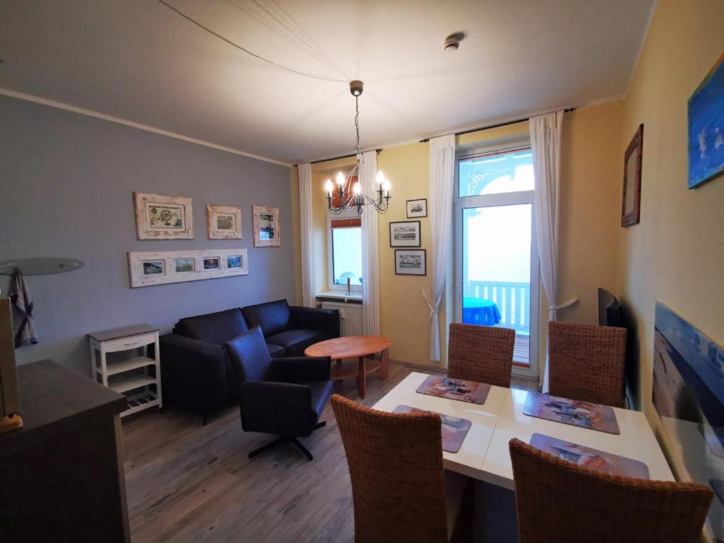 ein Wohnzimmer mit einem Sofa, einem Tisch und Stühlen in der Unterkunft Fürstenhof - App. 304 in Sassnitz