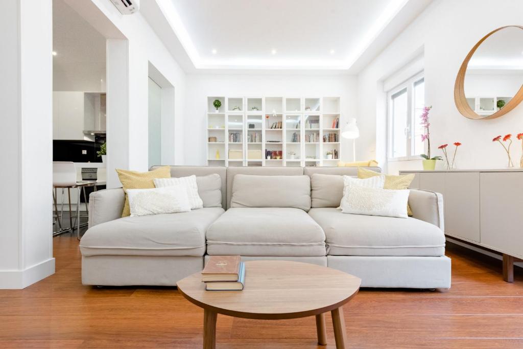 een witte woonkamer met een bank en een tafel bij Luxury Apartment Princesa in Madrid